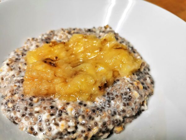 Overnight-Chia-Oats in einem weißen Teller mit zerdrückter Banane.