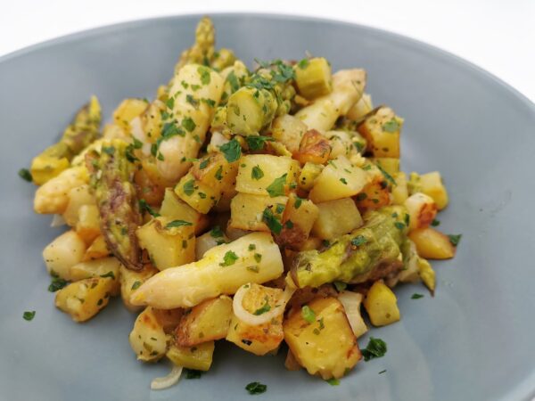 Spargel-Erdäpfel-Gröstl mit weißem und grünem Spargel und Kräutern, serviert in einem graublauen Suppenteller